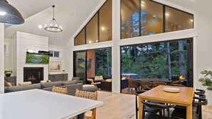 A spacious living room with a fireplace, a large dining table, and a cozy seating area.