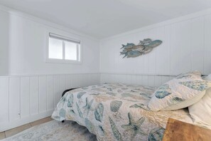Une chambre à coucher avec un lit, une fenêtre et un élément décoratif mural.