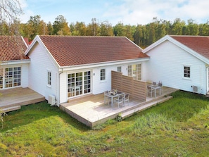 A row of white houses with red roofs, each featuring a patio with outdoor furniture. - Modern Holiday Haven in Laeso (Læsø)