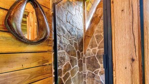 A wooden door with a stone wall and a metal ring. - Experience a Regenerative Farm in a New Tiny Home (Nixa)