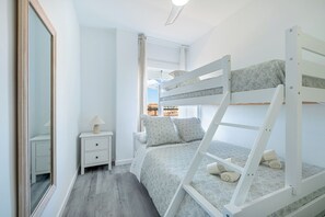 A bunk bed with a ladder, a bedside table with a lamp, and a window with curtains. - Brisa Marina luxury apart in fuengirola near the beach (Fuengirola)
