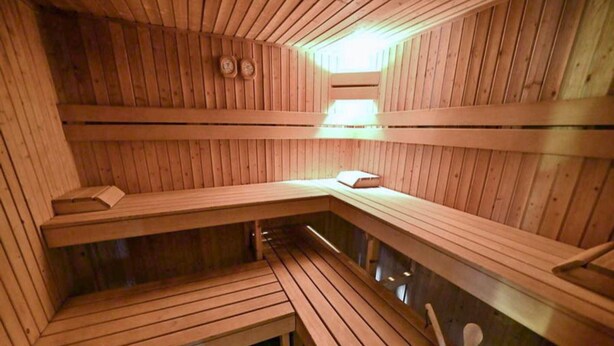 Eine Sauna mit Holzbänken, darunter ein Bank mit einem Buch.