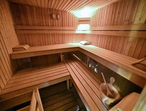 Un sauna avec des bancs en bois et un banc sur lequel est posé un livre.