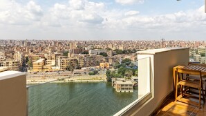 A balcony with a view of a cityscape and a river. - VESTA - Nile Zamalek Residence (Cairo)