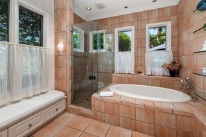 A modern bathroom with a glass-enclosed shower, a freestanding bathtub, and a vanity with a mirror.