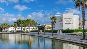 A waterfront property with a pool, palm trees, and a building labeled "APARTAMENTOS VENECIA". - Apartamentos Venecia  (Alcúdia)