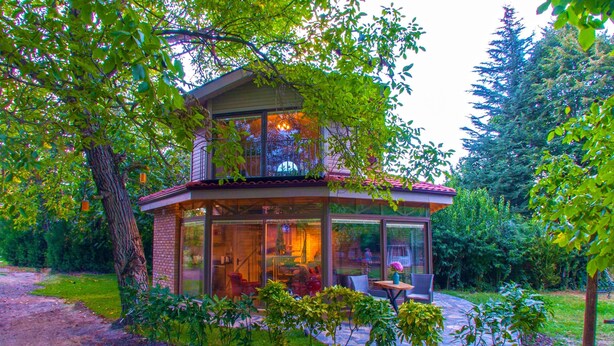 A modern house with a glass facade, a balcony, and a stone patio. - Junior Garden Villa (Sapanca)