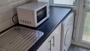 Cocina compacta con microondas, lavavajillas y lavadora.