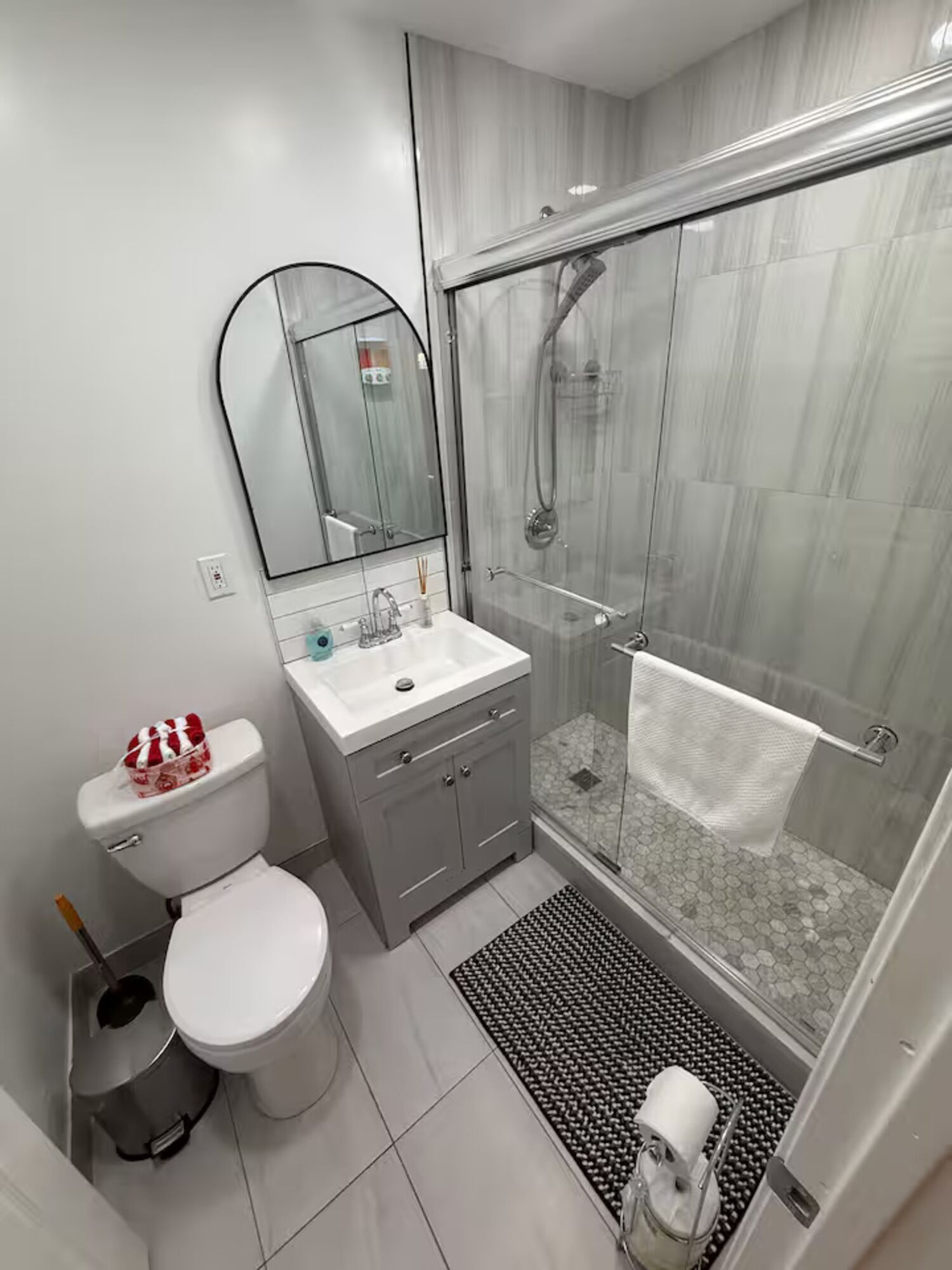 Un baño moderno con inodoro, lavamanos y ducha.