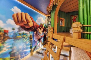 Une pièce dotée d’une grande fenêtre ornée d’un personnage de dessin animé, d’une table en bois, d’un mur vert et d’une petite fenêtre.