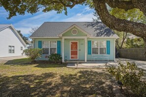 A single-story house with a front porch, a mailbox, and a small garden area.