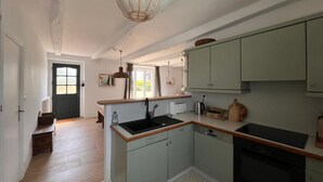 Una cocina moderna con una isla central, electrodomésticos integrados y un amplio ventanal.