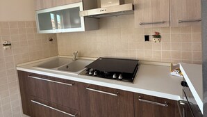 A modern kitchen with a built-in stove, a microwave, and a stainless steel range hood.
