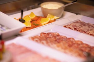 Un bufé con diferentes opciones de comida, incluyendo salmón, rodajas de limón y un bol de crema.