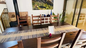 Un comedor con una mesa y sillas de madera, un cuadro en la pared y un reloj.
