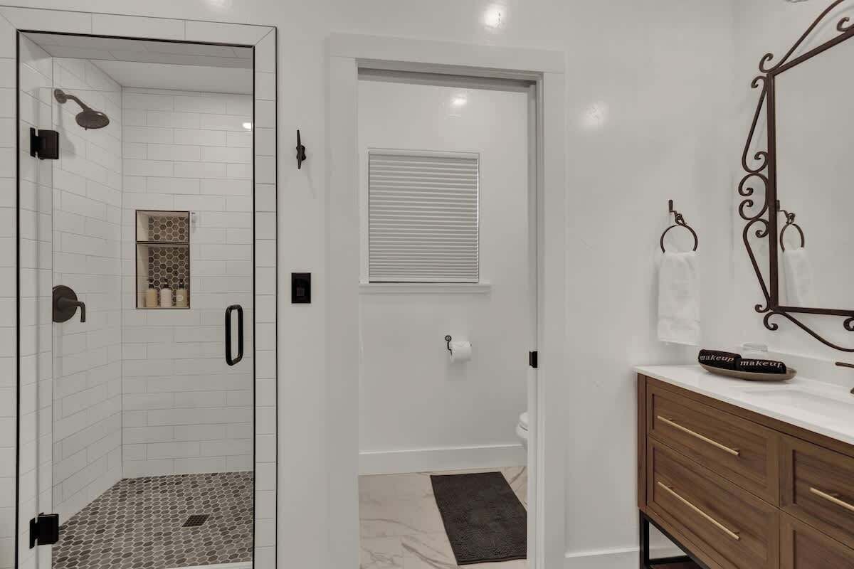 A bathroom with a shower, toilet, and vanity.