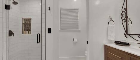 A bathroom with a shower, toilet, and vanity.