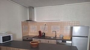 Eine Küche mit Mikrowelle, Herd, Spüle und Kühlschrank.