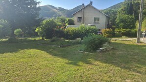 Ein Haus mit Garten, umgeben von Bergen.