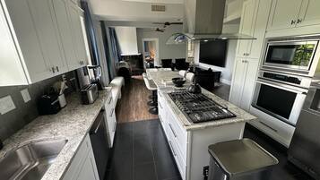 A modern kitchen with granite countertops, stainless steel appliances, and a central island.