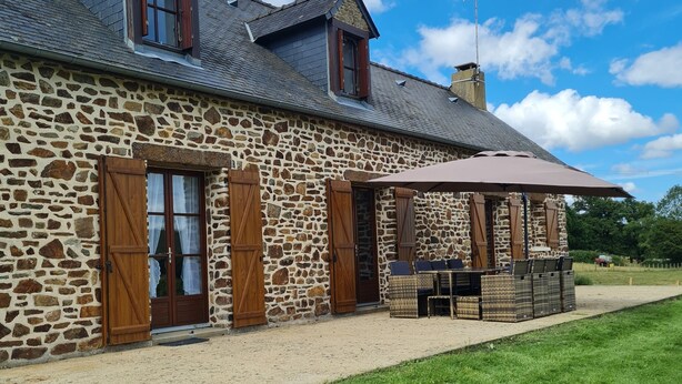 A stone building with a sloped roof, wooden shutters, and a covered patio area with outdoor seating. - La Parenthèse Verte, Guesthouse & Panorama (Mont-Saint-Jean)