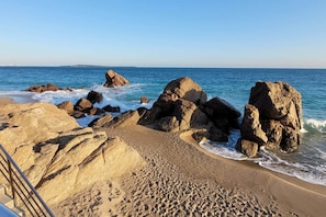 A beach with large rocks and waves.