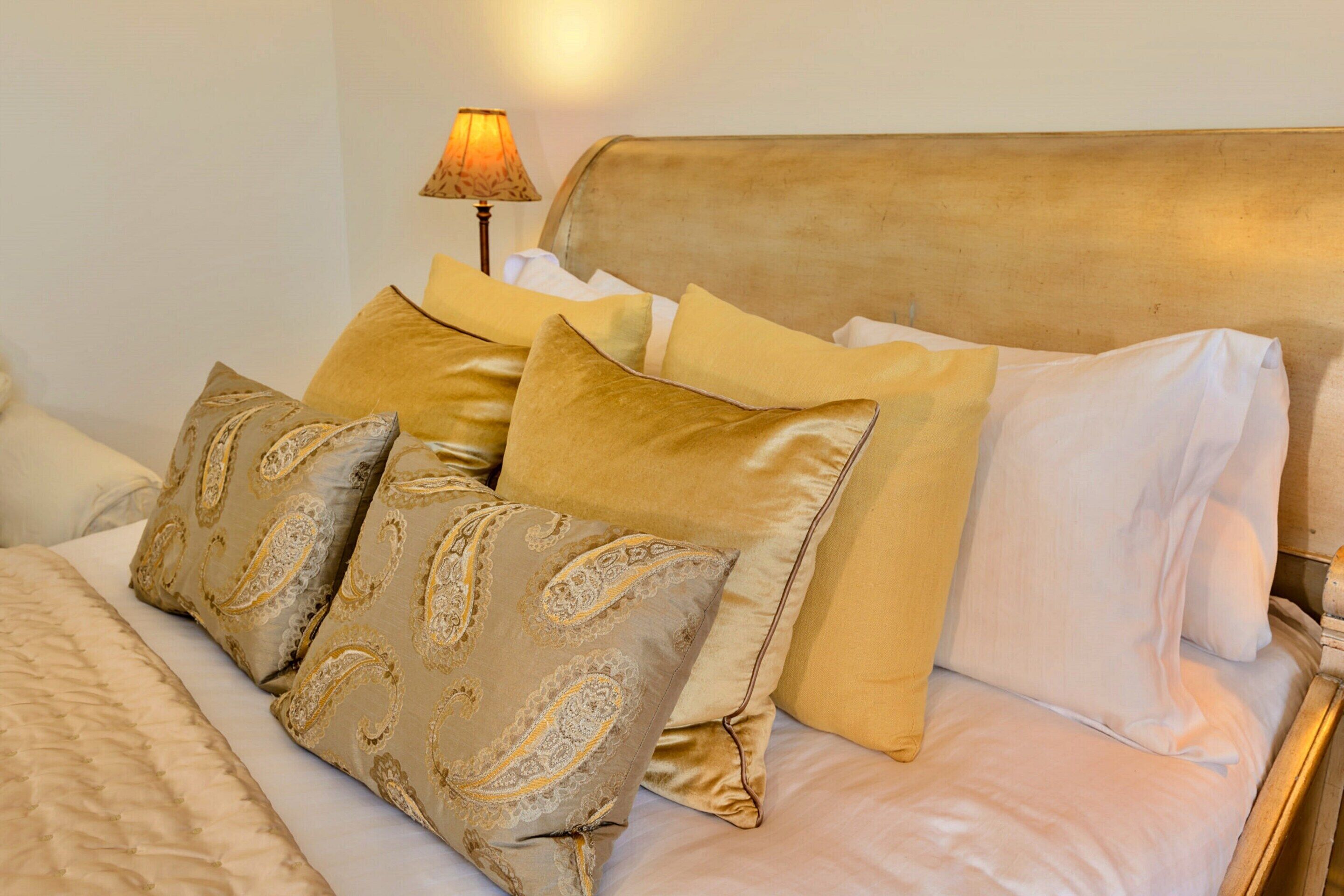 A neatly made bed with multiple pillows and a headboard.
