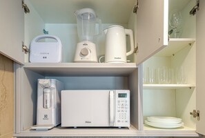 Eine Küche mit Mixer, Kaffeemaschine und Mikrowelle auf der Arbeitsfläche.