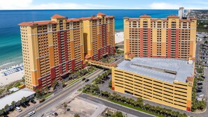 Un hotel moderno con varios balcones, estacionamiento subterráneo y vista al mar.