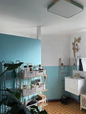Features a clean vanity with mirror, bamboo ladder, and decorative wall piece.