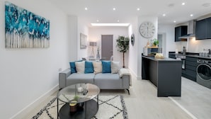 A modern living room with a grey sofa, a coffee table, and a painting on the wall. - Newly Converted 2BDR 1BA APT in Hounslow (Hounslow)