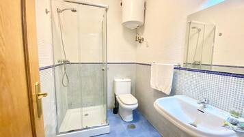 Een haardroger, handdoeken, zeep, toiletpapier