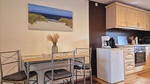 A compact kitchen with a dining area, a coffee maker, and a microwave. - Vacation home in Lieper Winkel (Rankwitz)