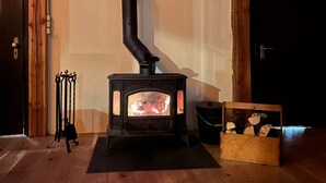 A wood-burning stove in a room with a sign reading "NATURFREUNDEHAUS" above it. - Bulk-Haus (Seesen)