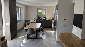 A modern kitchen with a dining area, built-in appliances, and a large window. - "LA SAUFFAZ - Your vacation in Savoie with family or friends (Faverges)