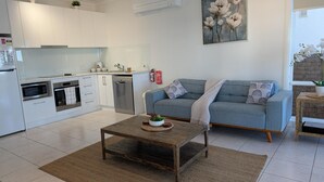 A modern kitchen with white cabinets, a built-in oven, and a dishwasher. - Sea Breeze @ Barrack Point (Barrack Point)