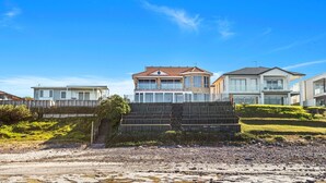 A beachfront property with a two-story house featuring a balcony, a white building with a balcony, and a smaller building with a flat roof. - Sea Breeze @ Barrack Point (Barrack Point)
