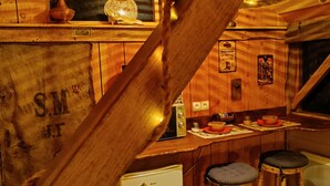A rustic kitchen with wooden walls, a vintage refrigerator, and bar stools. - P'tit ranch SPA PRIVATIF Ô Rêves Atypiques (Boucé)