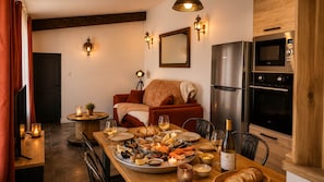 Zona pranzo con un piatto di pesce, vino e una bottiglia di vino Saint-Veran.