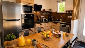 A modern kitchen with a refrigerator, oven, microwave, and coffee maker.