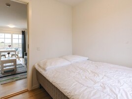 Un dormitorio con cama, ventana y área de comedor con mesa y sillas.