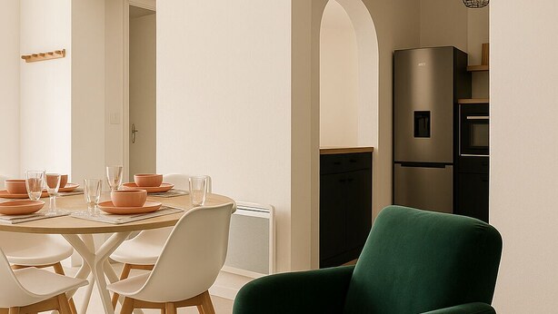 Un espace repas moderne avec une table ronde, des chaises blanches et un canapé vert.