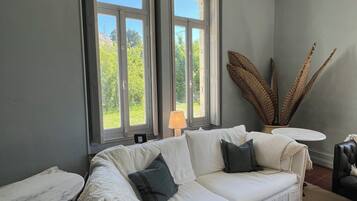 Una habitación con un sofá blanco, un tapete estampado y una lámpara.