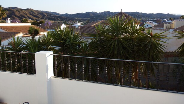Un balcon avec vue sur la ville et les montagnes.