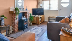 A cozy living room with a fireplace, a television, and a comfortable seating area.