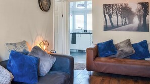 A living room with two sofas, a wall clock, and a painting.