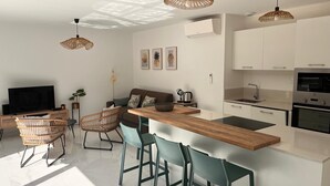 A modern kitchen with white cabinets, a wooden island, and a built-in oven.