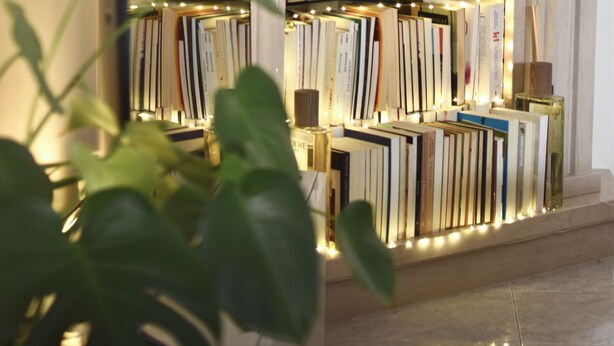 Un intérieur moderne agrémenté d’une cheminée, de bibliothèques et d’un miroir qui reflète la pièce.