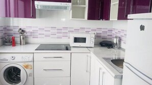A compact kitchen with a washing machine, microwave, and a sink. - Centro Madrid Rio - Monederos D (One bedroom apartment) (Madrid)