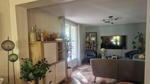 A living room with a grey sofa, a television, and a bookshelf. - Quiet country house, swimming pool, ideal for families - Aix en Provence (Aix-en-Provence)